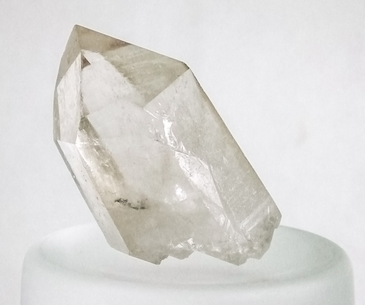 Cristal de cuarzo incoloro con caras prismáticas sobre fondo claro
