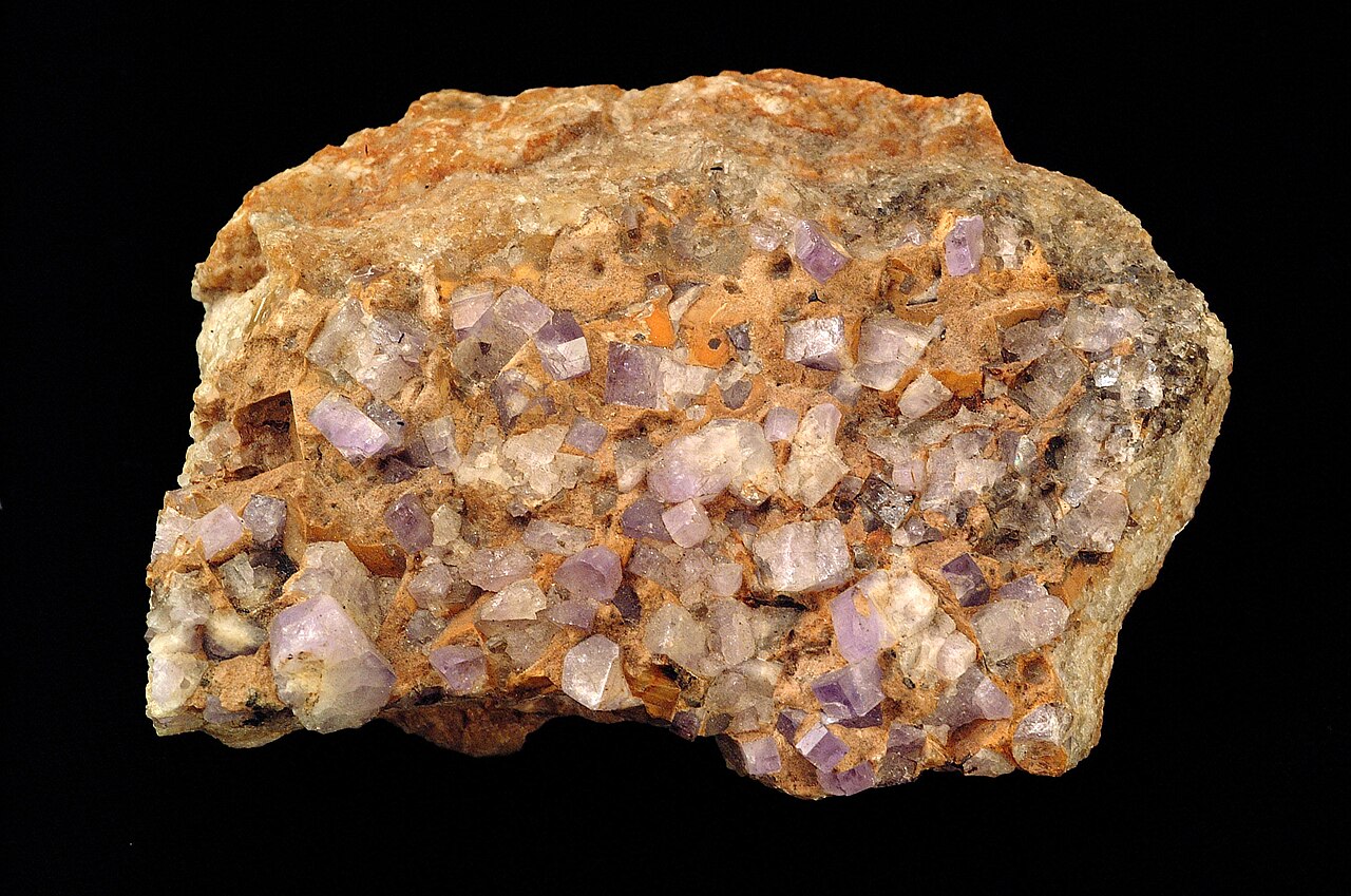 Cristales cúbicos de fluorita violeta clara en una matriz con apatito